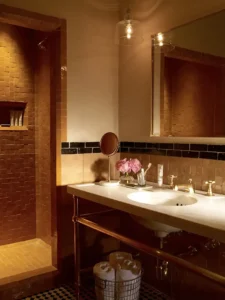 A moroccan vanity and tiled bathroom with walk-in shower in a courtyard king at the greenwich hotel
