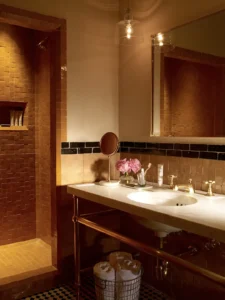 A moroccan vanity and tiled bathroom with walk-in shower in a courtyard king at the greenwich hotel