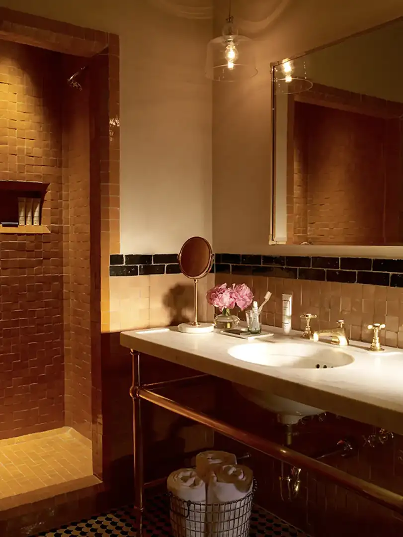 A moroccan vanity and tiled bathroom with walk-in shower in a courtyard king at the greenwich hotel