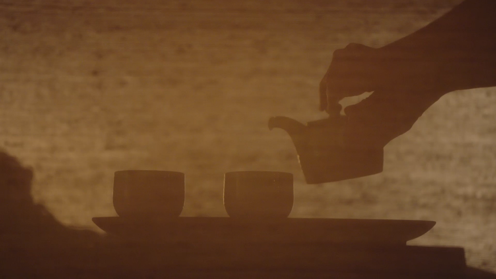 Silhouette of a person pouring tea in the spa