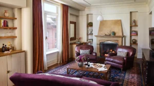 Looking over the sofa at the leather arm chairs on both sides of the fireplace.