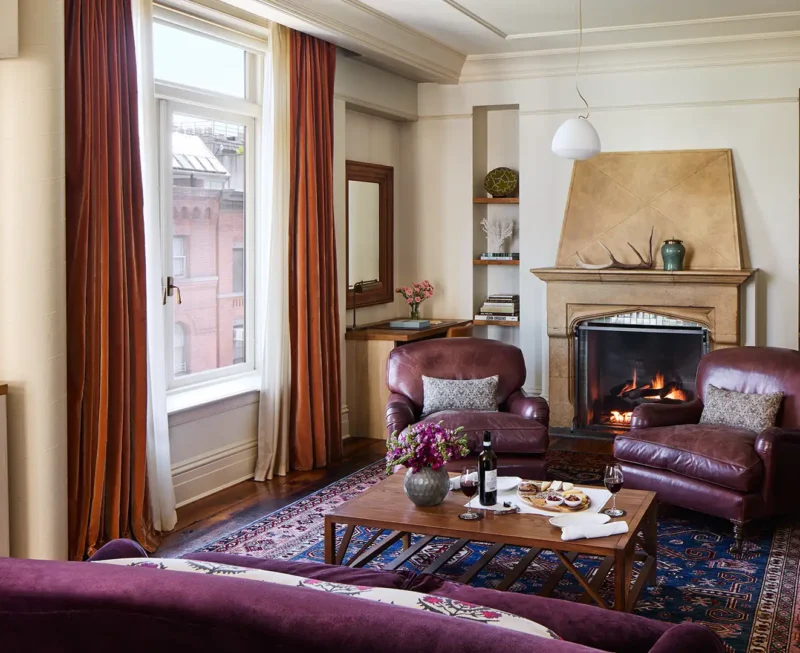 Looking over the sofa at the leather arm chairs on both sides of the fireplace.